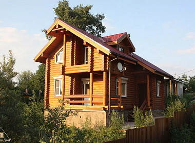 Двухэтажный дом из бревна с террасой и балконом